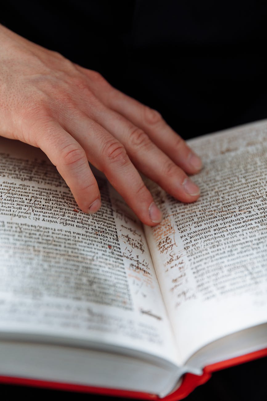 persons hand on book page